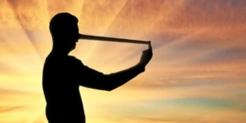 man in silhouette with long nose; concept of lies, deceit