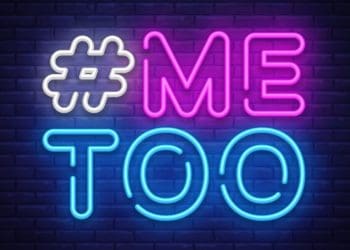 #MeToo in neon on dark brick wall