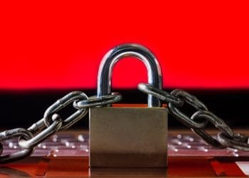 padlock and chains on keyboard with red screen