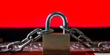 padlock and chains on keyboard with red screen