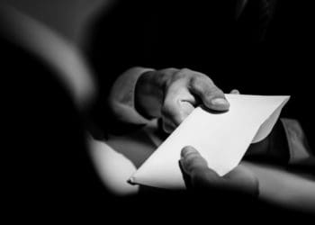 black and white image of businessman paying bribe