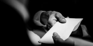 black and white image of businessman paying bribe