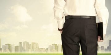 view of businessman from the back looking at city skyline