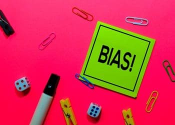 "bias" on green post-it note on pink background
