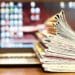 stack of newspapers on laptop