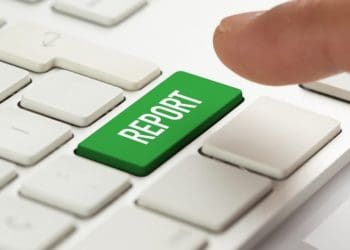 finger over green report button on white keyboard