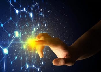 woman's hand touching beam of light on digital blue screen