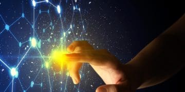 woman's hand touching beam of light on digital blue screen