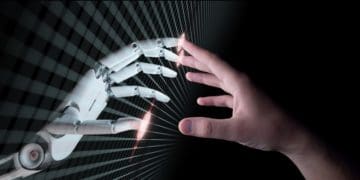 robot hand touching human hand through screen interface