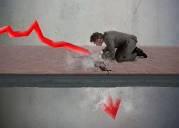 red arrow breaking through floor as businessman looks on