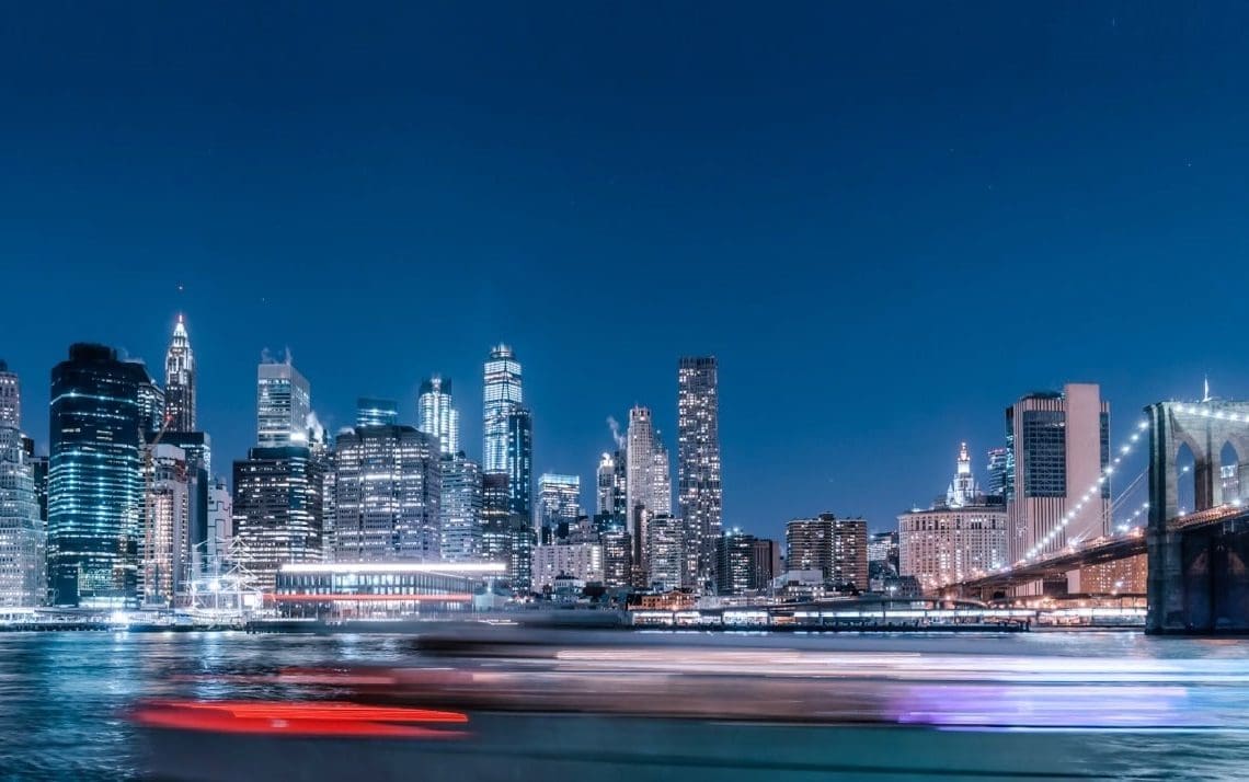 view of city skyline at night from the water