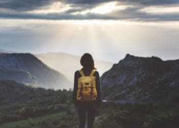 woman in yellow backpack looking out over landscape