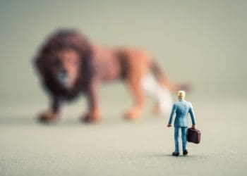 businessman facing giant lion
