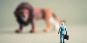 businessman facing giant lion