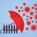 red umbrella protecting businessmen from COVID-19 virus