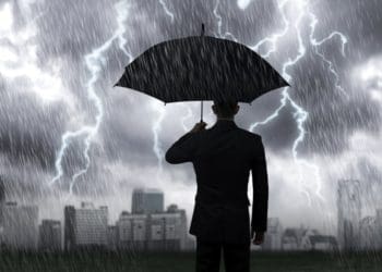 businessman in suit under umbrella in a storm