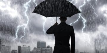 businessman in suit under umbrella in a storm