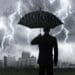 businessman in suit under umbrella in a storm
