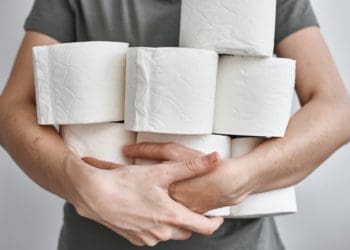 man holding multiple rolls of toilet paper