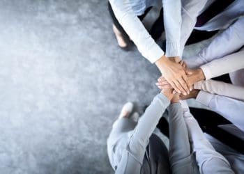 team in a huddle with hands in