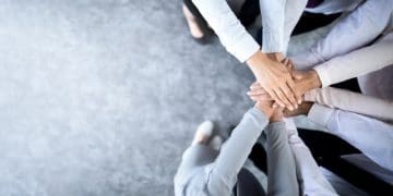 team in a huddle with hands in