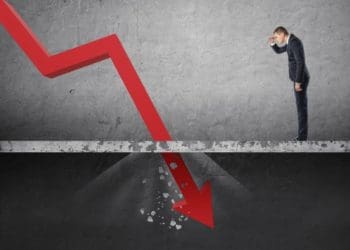 businessman watching red arrow fall through the floor