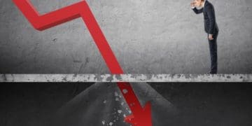 businessman watching red arrow fall through the floor