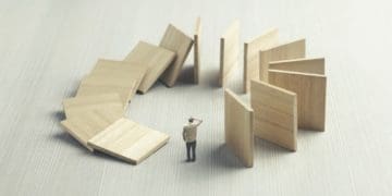 dominos falling around businessman