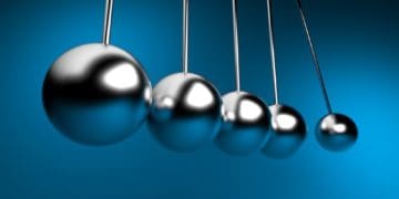 closeup of newton's cradle on blue background