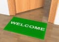 green welcome mat outside office door