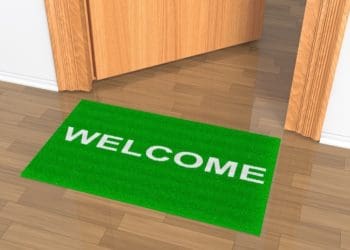 green welcome mat outside office door
