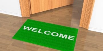 green welcome mat outside office door