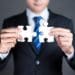 businessman connecting puzzle pieces