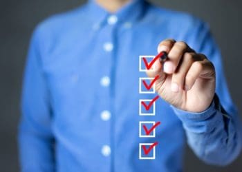 man in blue shirt checking boxes on screen