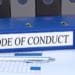 blue binder titled code of conduct