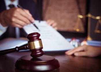 businesspeople reviewing contract beside gavel