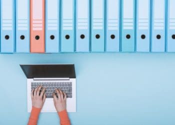 concept of data archives, woman on laptop with row of records