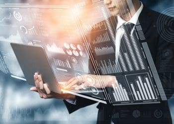man on laptop displaying financial charts on virtual screen