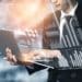 man on laptop displaying financial charts on virtual screen