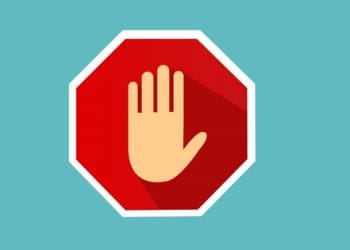 hand on stop sign on blue background