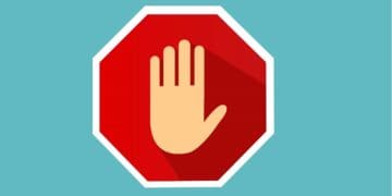 hand on stop sign on blue background
