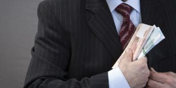 man pocketing bundles of cash