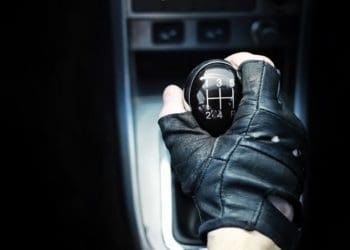 driver's hand on gear shift in car