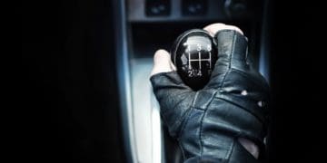 driver's hand on gear shift in car