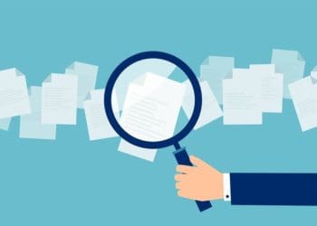 illustration of hand holding magnifying glass to review documents