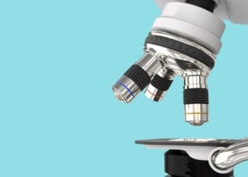 closeup of microscope against blue background