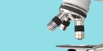 closeup of microscope against blue background