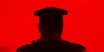 silhouette of police officer on red background