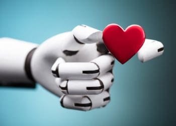 close-up of a robot's hand holding red heart