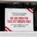 sign on restaurant window announcing takeout orders only